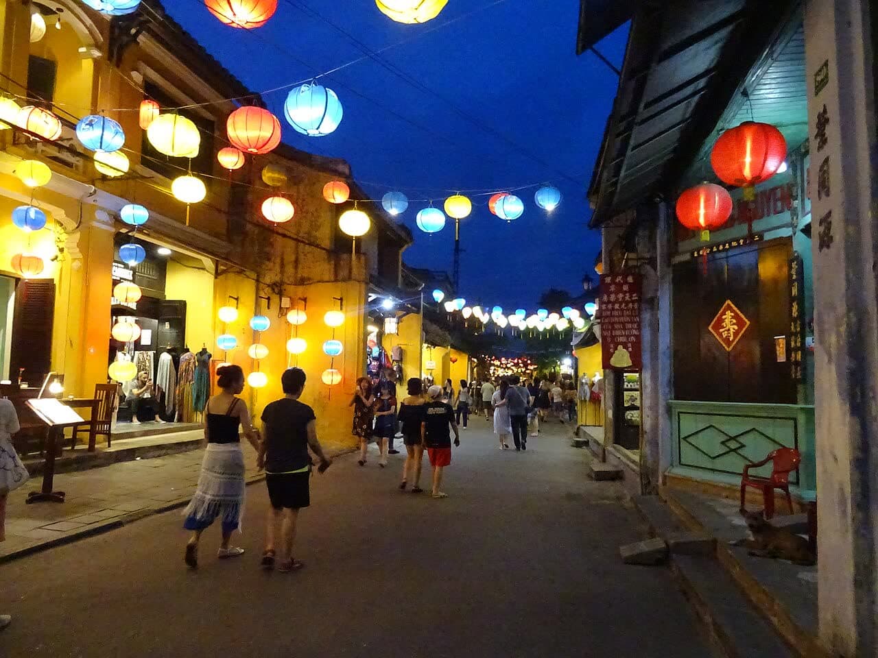 A street in Hoi An at dusk strung with colourful lanterns
